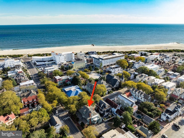 drone / aerial view featuring a water view and a beach view