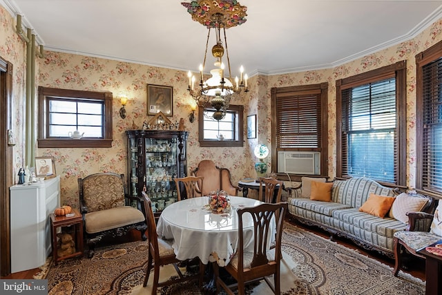 sitting room with crown molding, a wealth of natural light, and an inviting chandelier