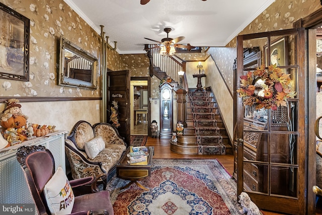 living room with ornamental molding, hardwood / wood-style flooring, and ceiling fan