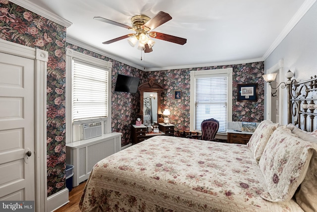 bedroom featuring multiple windows, wood-type flooring, crown molding, and ceiling fan