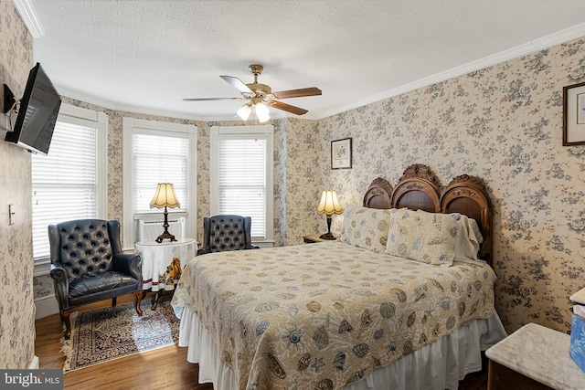 bedroom with ceiling fan, ornamental molding, a textured ceiling, and hardwood / wood-style floors