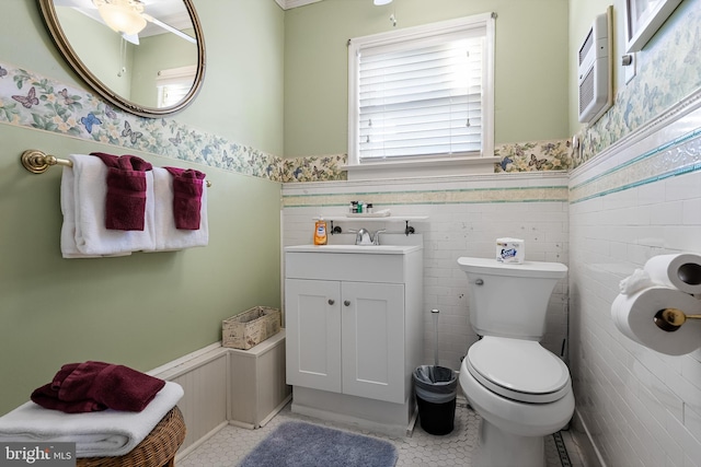 bathroom with vanity, toilet, tile walls, and tile patterned flooring