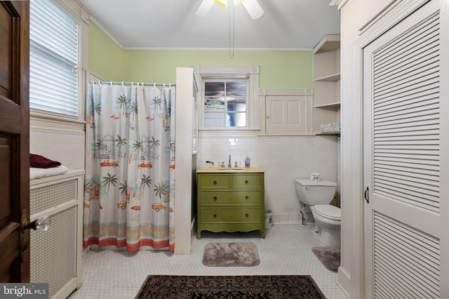 bathroom with ceiling fan, tile walls, toilet, ornamental molding, and sink