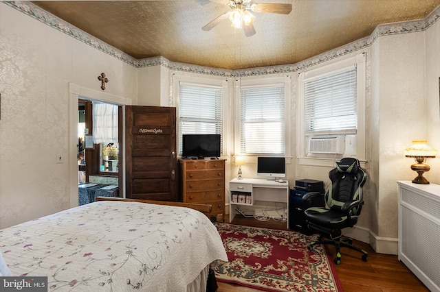 bedroom featuring cooling unit, wood-type flooring, and ceiling fan