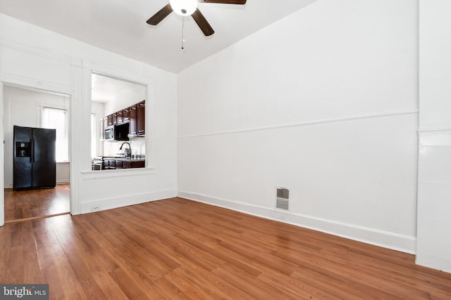 unfurnished living room with wood-type flooring, vaulted ceiling, and ceiling fan