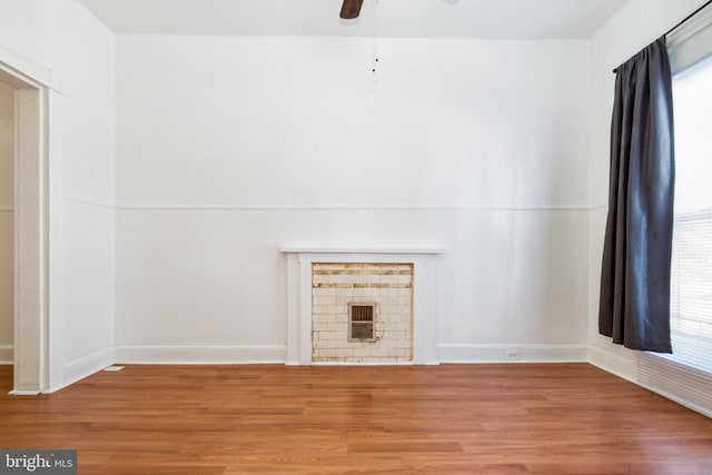 unfurnished living room featuring hardwood / wood-style floors, ceiling fan, and a wealth of natural light