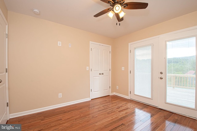 interior space featuring baseboards, a ceiling fan, and wood finished floors