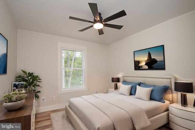 bedroom featuring wood finished floors, baseboards, and ceiling fan