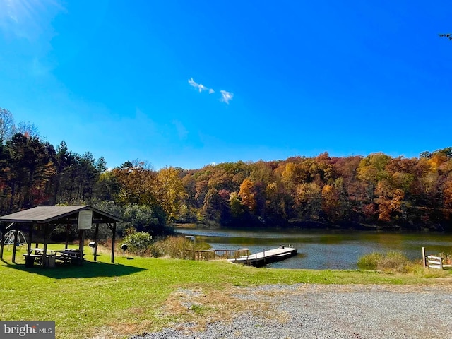 dock area featuring a forest view, a yard, a gazebo, and a water view