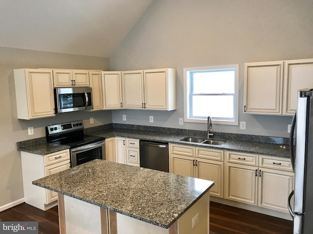 kitchen featuring stainless steel appliances, a sink, dark wood-type flooring, dark stone counters, and high vaulted ceiling