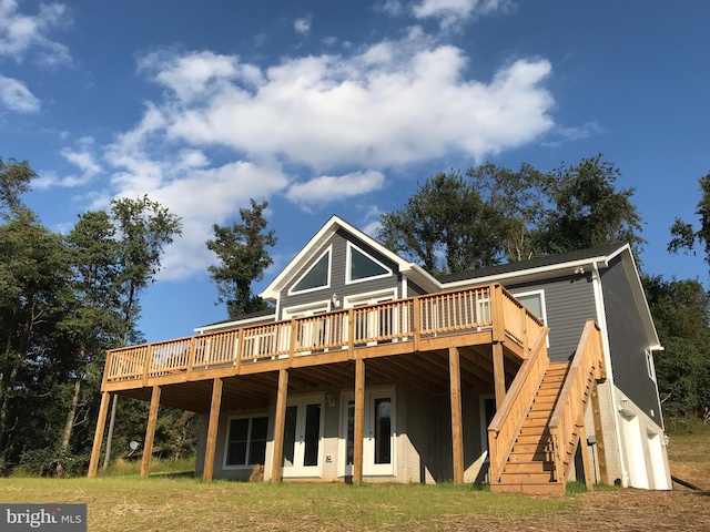 back of property with a garage, a deck, stairs, and french doors