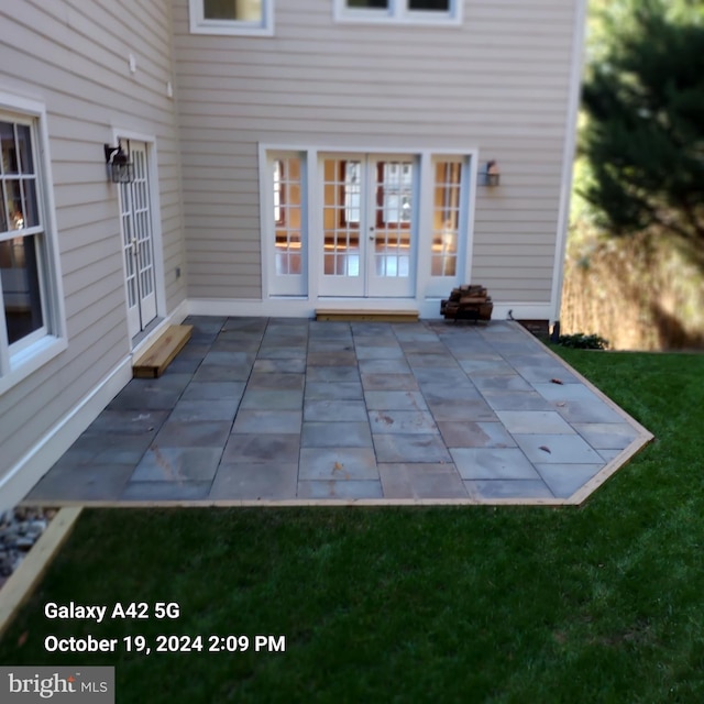 back of house featuring a patio area, french doors, and a lawn