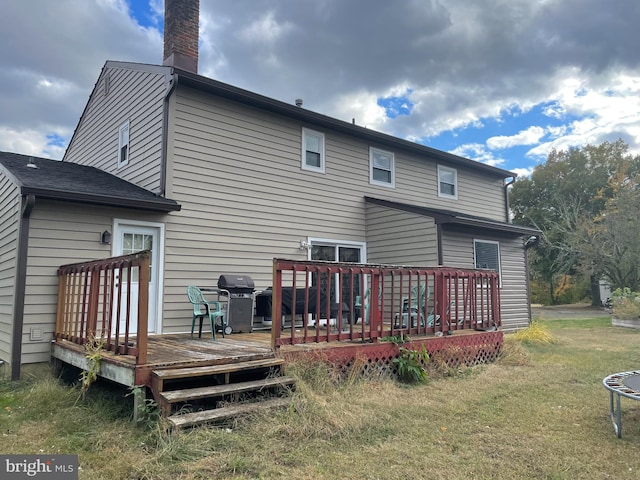 back of property featuring a yard and a deck