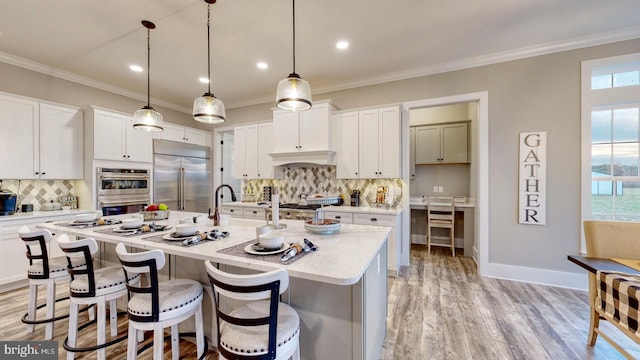 kitchen with a wealth of natural light, white cabinets, and appliances with stainless steel finishes