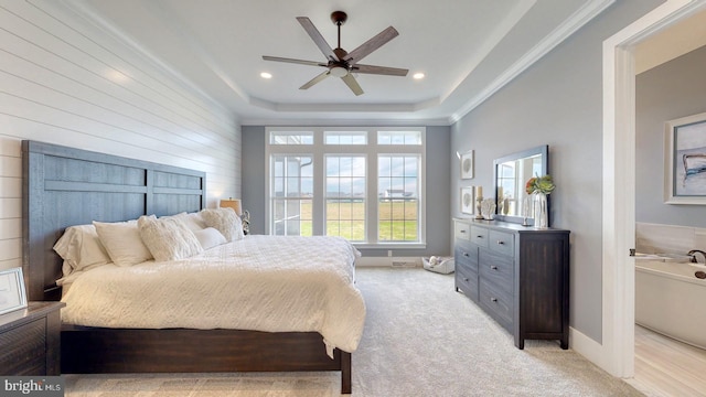 carpeted bedroom featuring a raised ceiling, ceiling fan, and ornamental molding