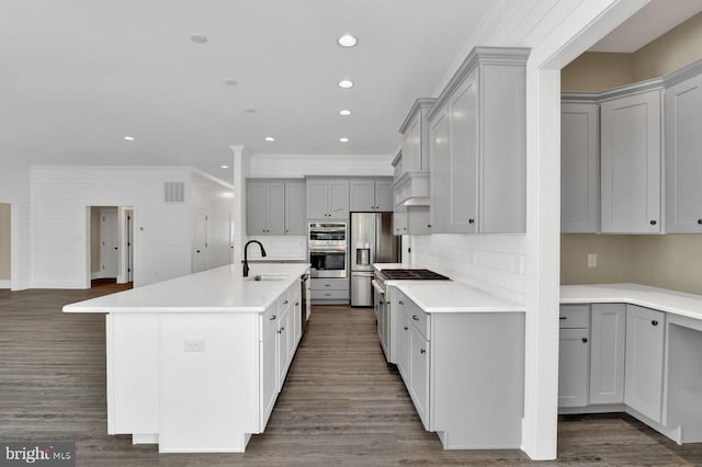 kitchen featuring gray cabinets, a kitchen island with sink, dark wood-type flooring, and sink