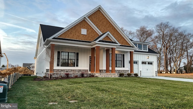 craftsman house with covered porch, a garage, and a front yard