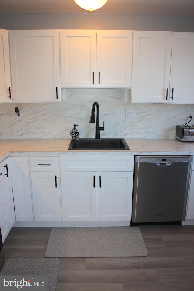 kitchen with white cabinetry, stainless steel dishwasher, dark wood-type flooring, and sink