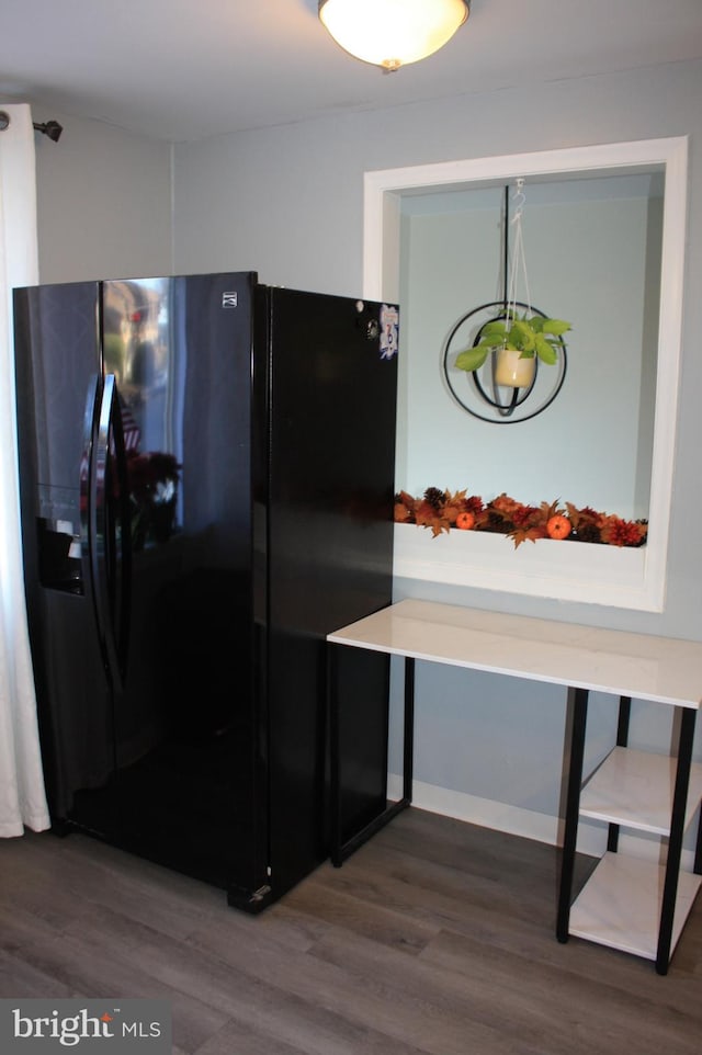 kitchen with black fridge and dark wood-type flooring