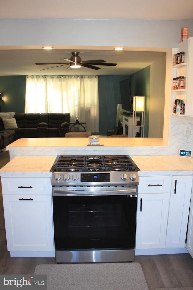 kitchen with tasteful backsplash, gas range, dark hardwood / wood-style flooring, and white cabinets