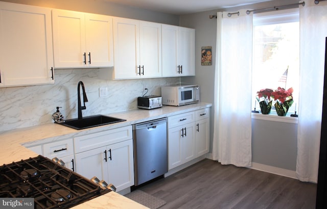 kitchen featuring dishwasher, sink, light stone countertops, dark hardwood / wood-style flooring, and white cabinetry