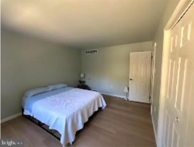 bedroom featuring wood-type flooring and a closet