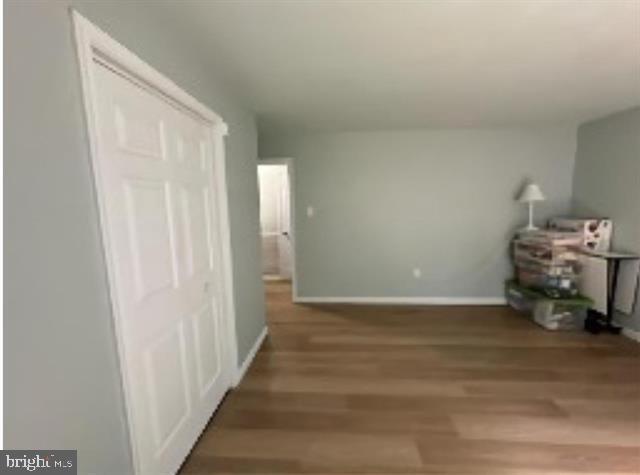 hallway with hardwood / wood-style flooring