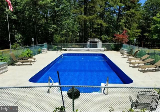 view of pool with a storage shed and a patio area