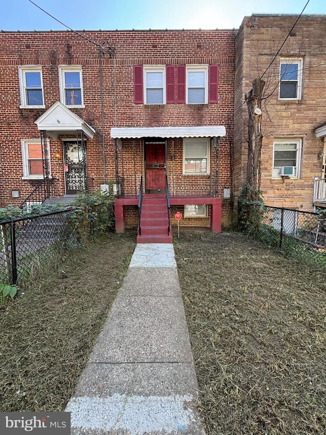 townhome / multi-family property featuring covered porch, cooling unit, and a front lawn