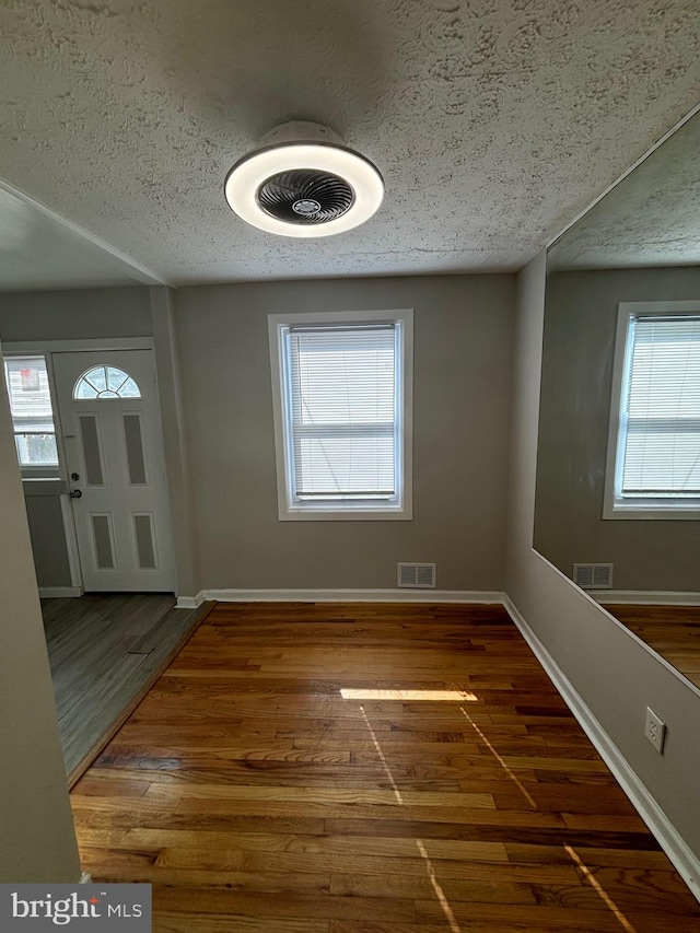 entrance foyer featuring a textured ceiling and dark hardwood / wood-style flooring