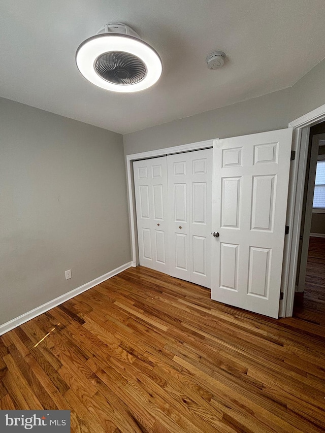 unfurnished bedroom featuring a closet and dark hardwood / wood-style floors