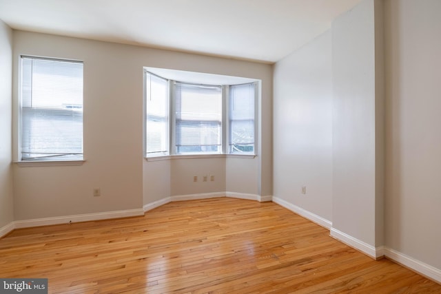 empty room with light hardwood / wood-style flooring and a healthy amount of sunlight