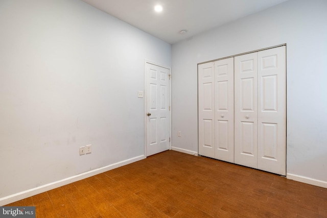 unfurnished bedroom with a closet and hardwood / wood-style flooring