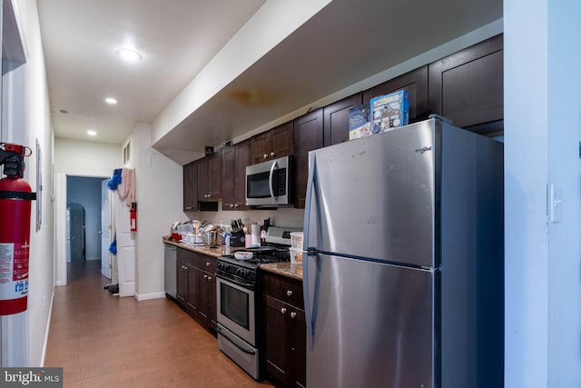 kitchen with dark stone countertops, stainless steel appliances, and dark brown cabinets