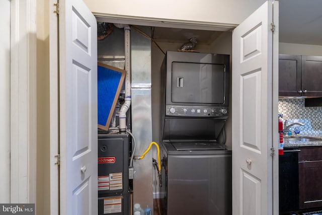 washroom featuring stacked washing maching and dryer and sink