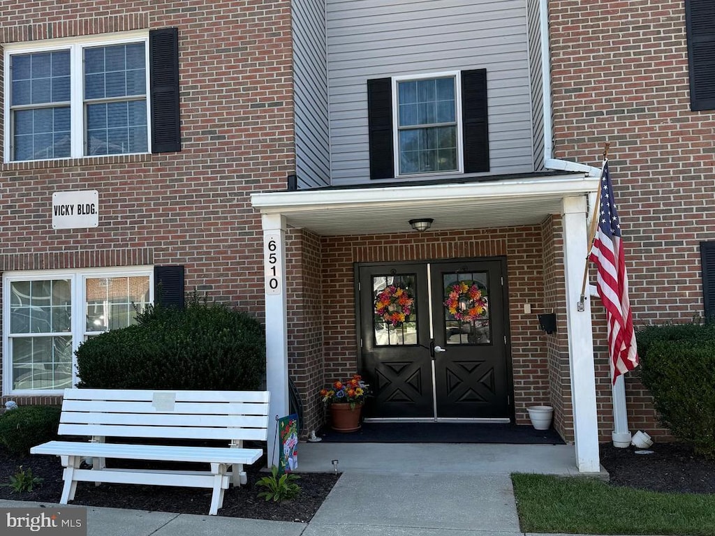 property entrance featuring french doors and brick siding