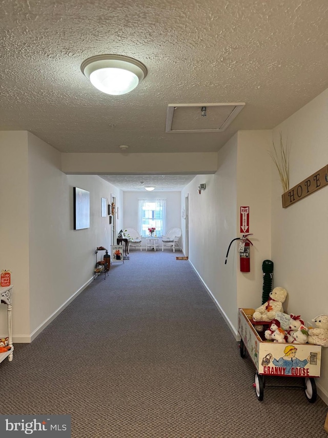 hallway with carpet and a textured ceiling