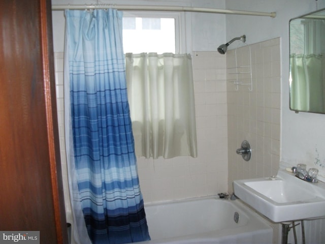 bathroom featuring sink and shower / bath combination with curtain