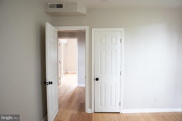 hallway with light hardwood / wood-style floors