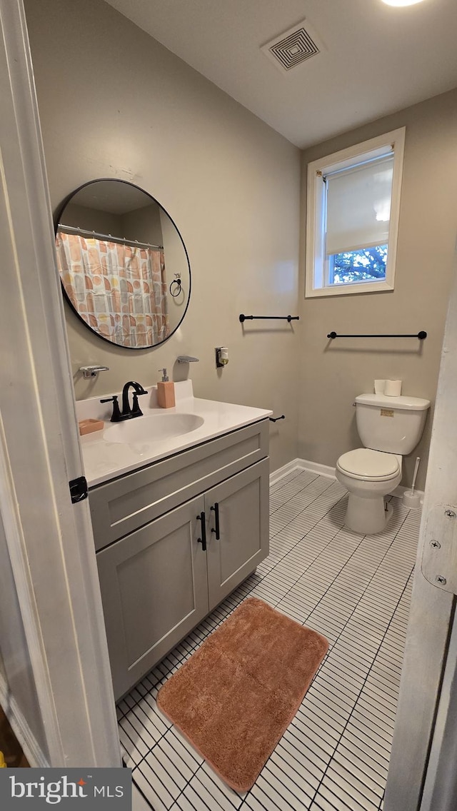 bathroom with vanity, toilet, and tile patterned flooring