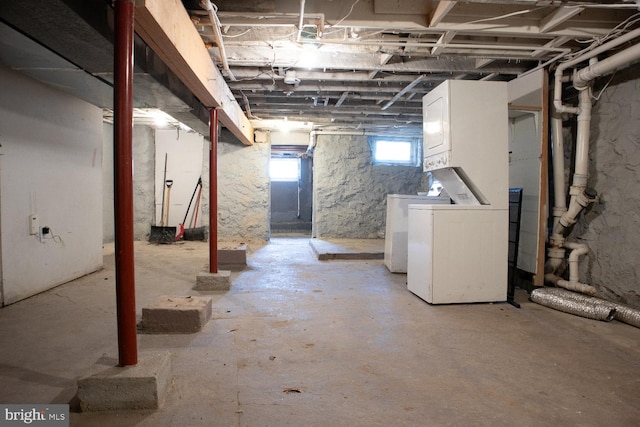 basement featuring stacked washer and clothes dryer