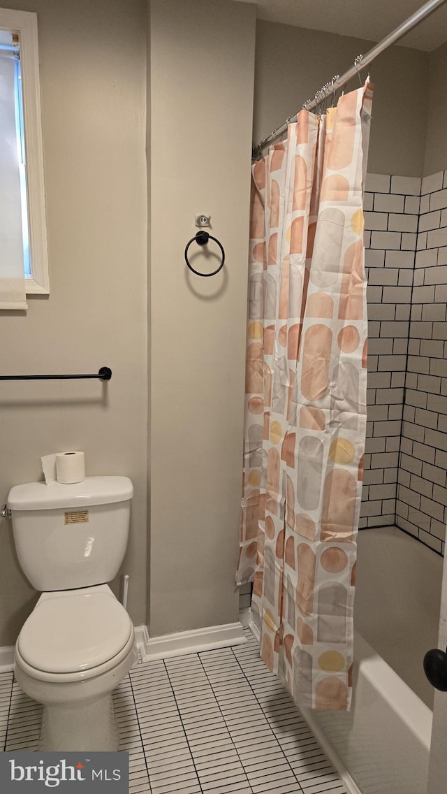 bathroom featuring toilet, tile patterned floors, and shower / tub combo