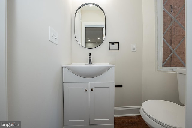 bathroom with vanity, toilet, and hardwood / wood-style flooring