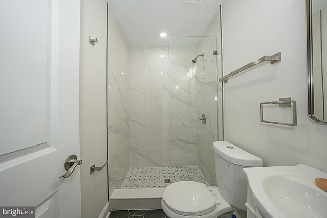 bathroom featuring a tile shower, toilet, tile patterned floors, and vanity