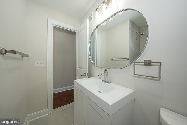 bathroom featuring vanity, hardwood / wood-style floors, toilet, and walk in shower