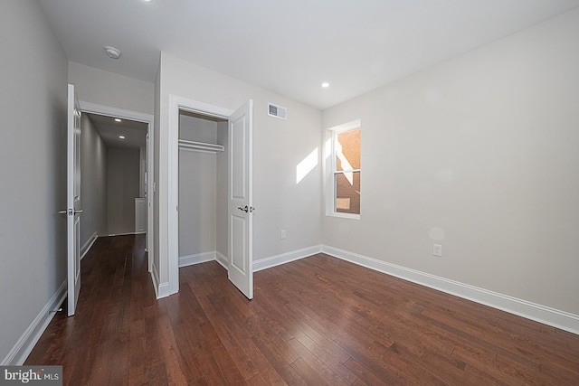 unfurnished bedroom featuring dark wood-type flooring and a closet