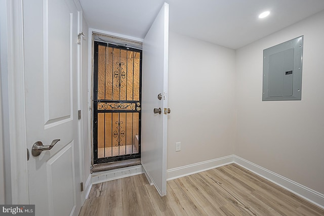 interior space featuring electric panel and light hardwood / wood-style flooring