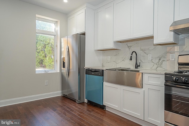 kitchen with appliances with stainless steel finishes, white cabinets, exhaust hood, and dark hardwood / wood-style flooring