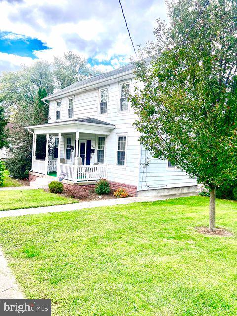 view of front of house featuring a front yard and covered porch