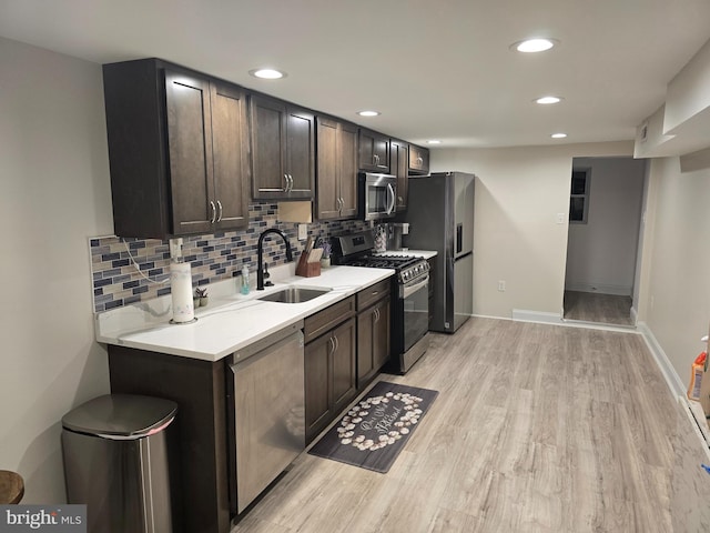 kitchen featuring decorative backsplash, dark brown cabinets, appliances with stainless steel finishes, light hardwood / wood-style floors, and sink